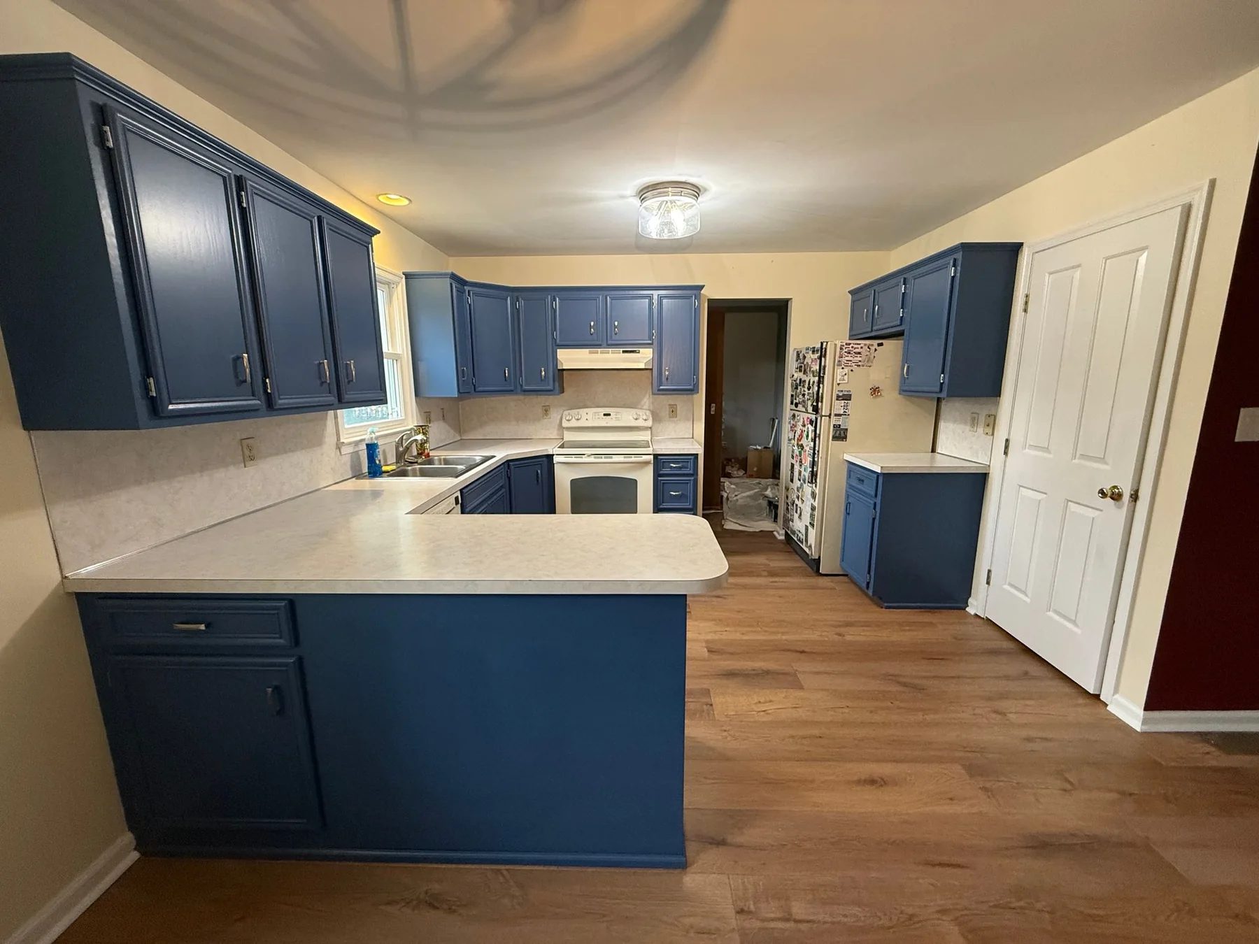 Real navy kitchen cabinet refinishing work by Premier Painting Solutions